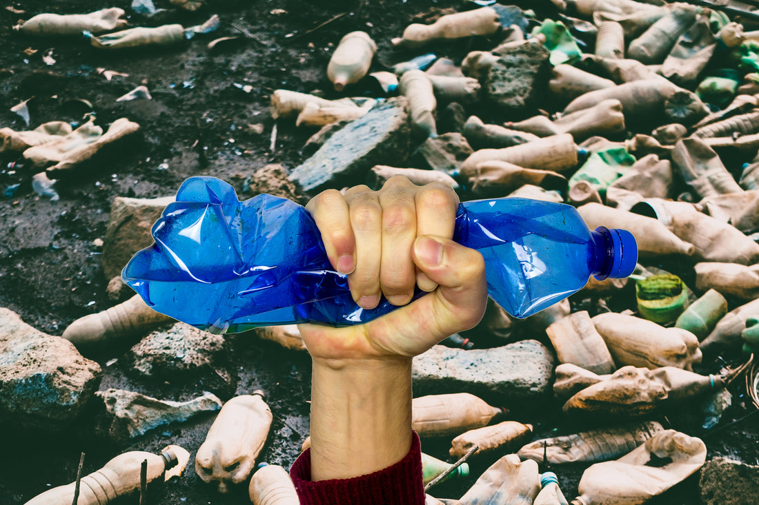 Littorary - Plastic Bottle Crushed in Fist - Background of Plastic Bottle Pollution - Julia Joppien